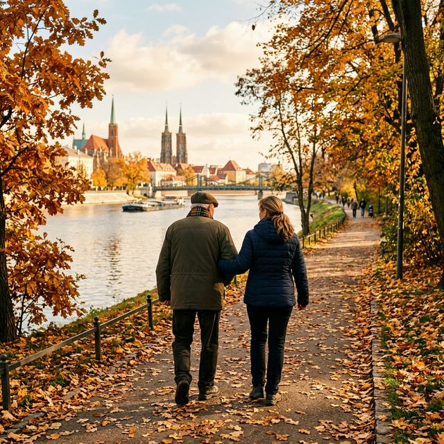 Opiekunka i senior spacerują nad Odrą we Wrocławiu jesienią — ujęcie z tyłu, widok na katedrę i mosty